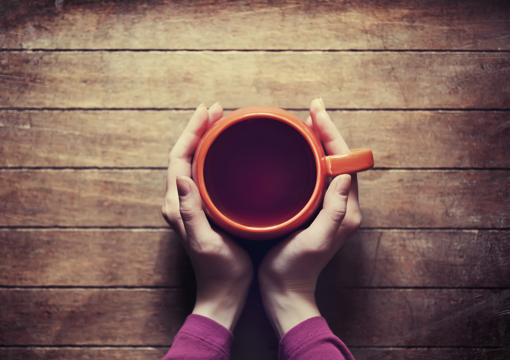 two hands holding tea cup startup